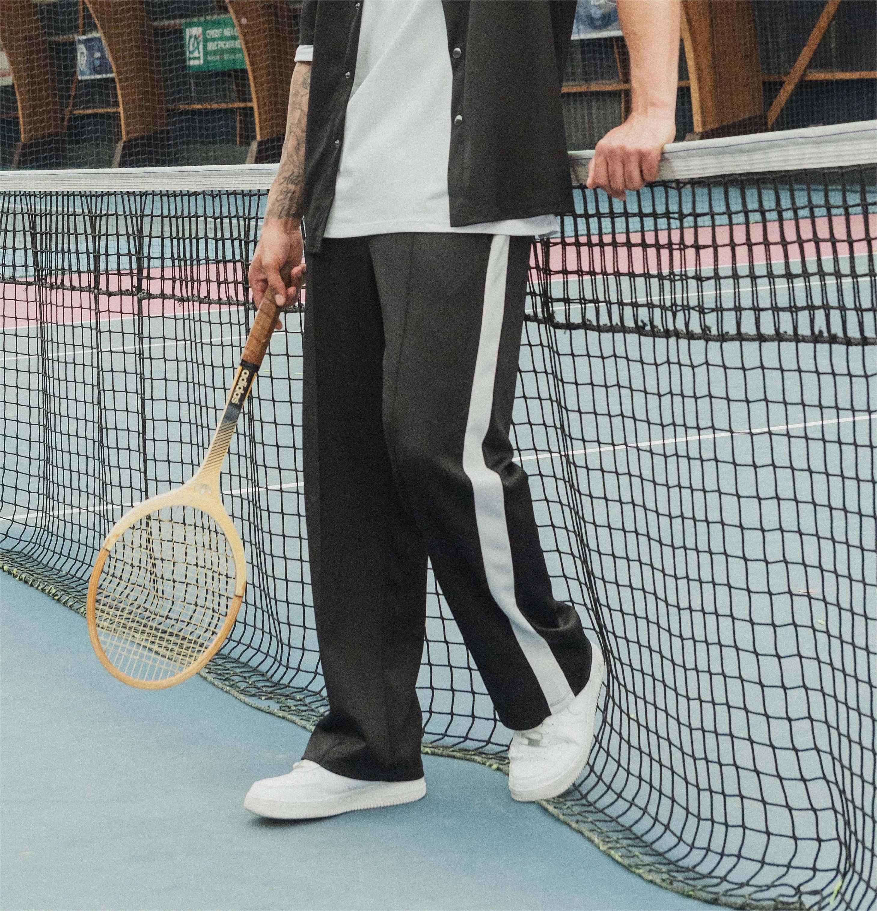 Wide jogging pants with bands along the legs